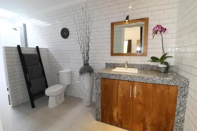 a bathroom with a sink and a toilet and a mirror at 2 villa complex near Atlas beach in Canggu