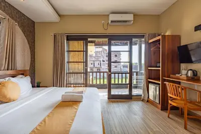 a bedroom with a large bed and a balcony at Cove Kavana in Canggu