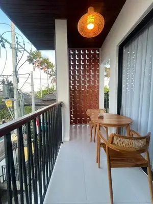 a wooden table and a chair on a balcony at Braban Sari Bali in Seminyak