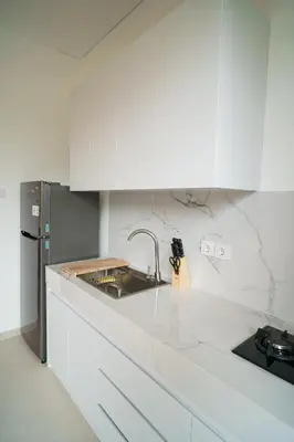 a white kitchen with a sink and a refrigerator at Canggu Zen Villa - 2 BR Villa in Berawa in Canggu