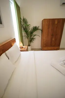 a bedroom with a white bed and a potted plant at Canggu Zen Villa - 2 BR Villa in Berawa in Canggu