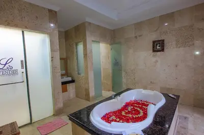 a bathroom with a large tub filled with red beads at LV Villa Kuta Bali in Jimbaran