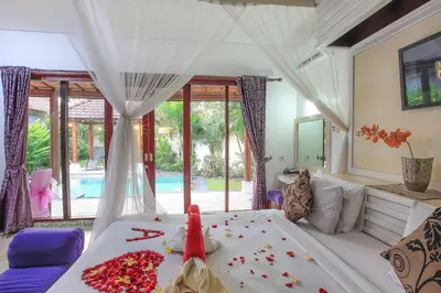 a bedroom with a bed with flowers on it at LV Villa Kuta Bali in Jimbaran