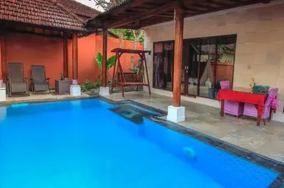 a swimming pool in front of a house at LV Villa Kuta Bali in Jimbaran