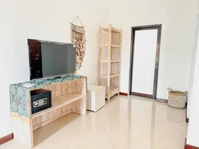 a living room with a flat screen tv on a stand at Bby Diamond Villa in Seminyak