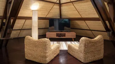 a living room with two chairs and a television at Villa Asta in Seminyak