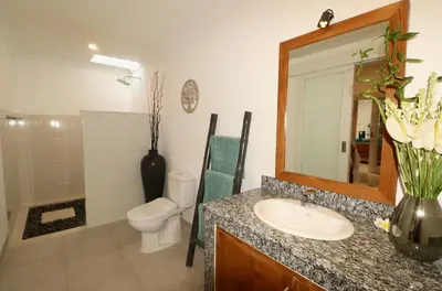 a bathroom with a sink and a toilet and a mirror at 3 neighbour villas 3 pools near Atlas Beach Club in Canggu