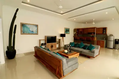 a living room with a couch and a tv at 3 neighbour villas 3 pools near Atlas Beach Club in Canggu