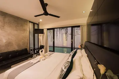 a bedroom with a bed with a ceiling fan at Le Retreat Canggu, 3BR Luxury Villa, Bali's Best Location in Canggu