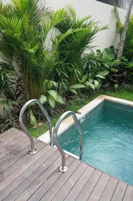 a small swimming pool sitting next to a wooden deck at Berawa 2BR Private Pool Leon Villa by Bali Bliss Properties in Canggu