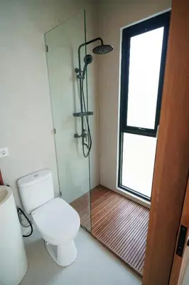 a bathroom with a toilet and a glass shower at Berawa 2BR Private Pool Leon Villa by Bali Bliss Properties in Canggu