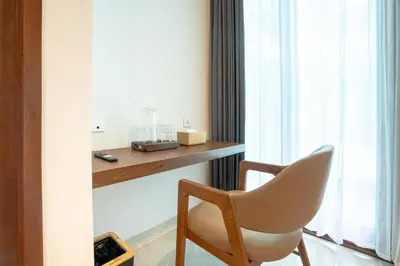 a white chair sitting in front of a window at Miles Coliving in Kerobokan