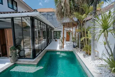 a swimming pool in the backyard of a home with a house at Villa bossa nova in Seminyak
