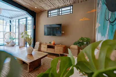 a living room with a table and a tv at Villa bossa nova in Seminyak