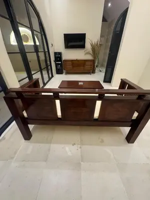 a large wooden bed in a room with a tv at Antanaya Villa Seminyak in Seminyak