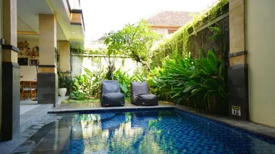 a swimming pool in the middle of a house at BAGUS Guest House in Legian