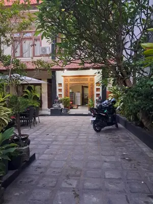 a motorcycle parked in the courtyard of a building at SURFARIS INN on poppies 2 in Legian