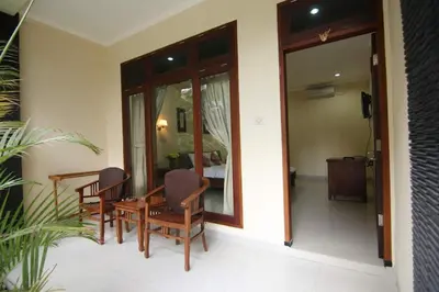 a patio with chairs and a table and a mirror at SURFARIS INN on poppies 2 in Legian