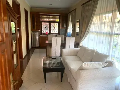 a living room with a white couch and a table at Villa D Lima Top Floor in Kuta
