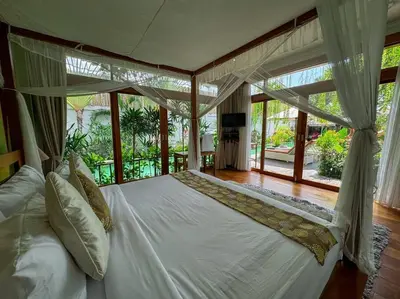 a bedroom with a white bed with a large window at Party Size 4 Bedroom Villa Kerobokan in Seminyak