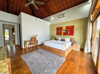 a bedroom with a large bed and a wooden floor at Party Size 4 Bedroom Villa Kerobokan in Seminyak