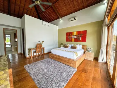 a bedroom with a large bed and a rug at Party Size 4 Bedroom Villa Kerobokan in Seminyak