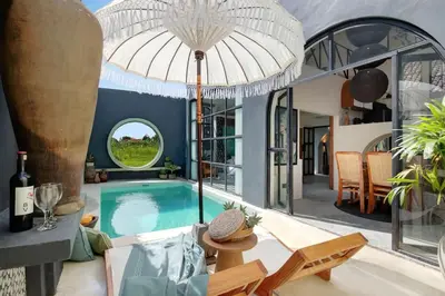 a house with a swimming pool and an umbrella at Casa Ghitani Kerobokan 1 Bed Enclose Living room WH2 in Umalas