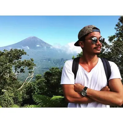 a man standing with his arms crossed in front of a mountain at Casa Ghitani Kerobokan 1 Bed Enclose Living room WH2 in Umalas