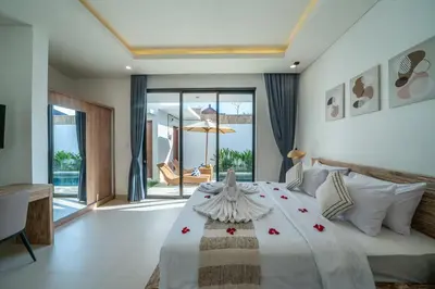 a bedroom with a large white bed with flowers on it at Villa Bagus Seminyak in Kerobokan