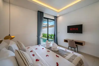 a bedroom with a bed and a desk and a window at Villa Bagus Seminyak in Kerobokan