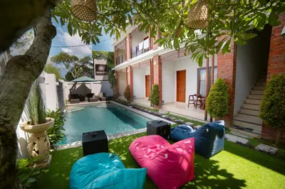 a backyard with a swimming pool and a house at Dikubu Bali Villa and Suites in Kerobokan