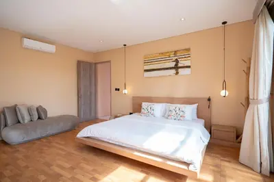 a bedroom with a large white bed and a couch at Villa Biku in Umalas