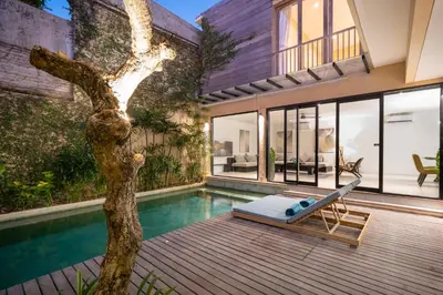 a house with a swimming pool and a tree at Villa Biku in Umalas