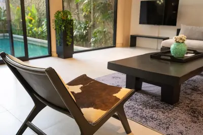 a living room with a table and a chair at Villa Biku in Umalas