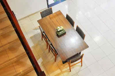 a table with chairs and a vase of flowers on it at Kefi Villa Seminyak in Seminyak