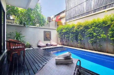a small swimming pool in a backyard with a bench at Kefi Villa Seminyak in Seminyak