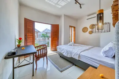 a bedroom with a bed and a table and a desk at 3 Bd Pvt House with big common pool and Gym in Nusa Dua