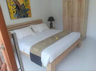 a bedroom with a large bed with a wooden frame at Villa umara 2 kerobokan close to seminyak in Seminyak