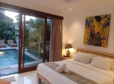 a bedroom with a large bed and a pool at Villa umara 2 kerobokan close to seminyak in Seminyak