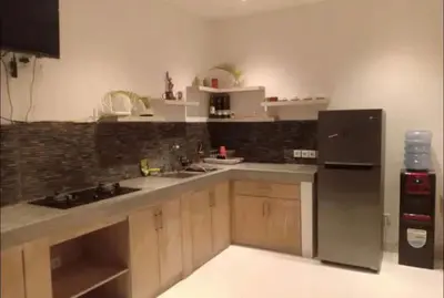 a kitchen with a stainless steel refrigerator and wooden cabinets at Villa umara 2 kerobokan close to seminyak in Seminyak