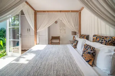 a bedroom with a large bed with a window at Villa Tara by Villa Finder in Seminyak