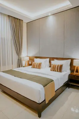 a bedroom with a large white bed with pillows at Shira House Bali in Legian