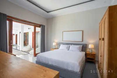 a bedroom with a white bed and a large window at Two Bedroom Villa with Outdoor Pool in Umalas