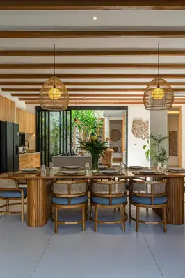 a dining room with wooden tables and chairs at Casa Kameelya - Modern Tropical 4BR Villa in Central Canggu in Canggu