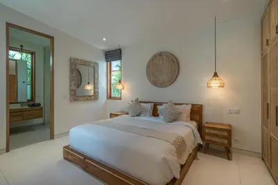 a bedroom with a large white bed and a mirror at Casa Kameelya - Modern Tropical 4BR Villa in Central Canggu in Canggu