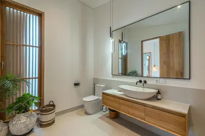 a bathroom with a sink and a toilet and a mirror at Casa Kameelya - Modern Tropical 4BR Villa in Central Canggu in Canggu