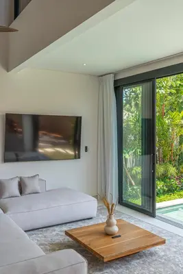a living room with a couch and a table at Casa Kameelya - Modern Tropical 4BR Villa in Central Canggu in Canggu