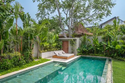 a swimming pool in the backyard of a villa at Casa Kameelya - Modern Tropical 4BR Villa in Central Canggu in Canggu