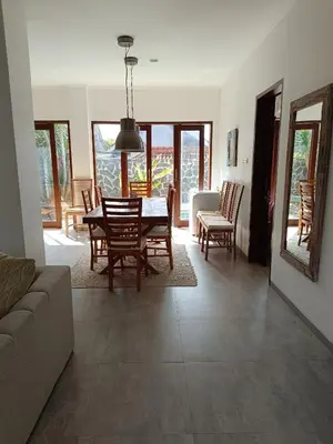 a living room with a dining room table and chairs at Casa Dijaweqo in Jimbaran