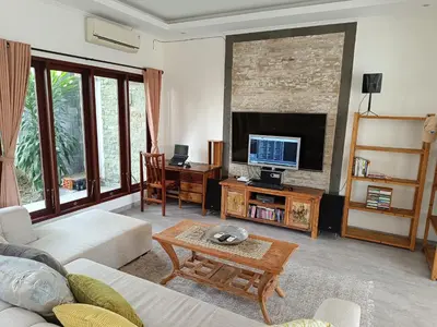 a living room with a couch and a tv at Casa Dijaweqo in Jimbaran